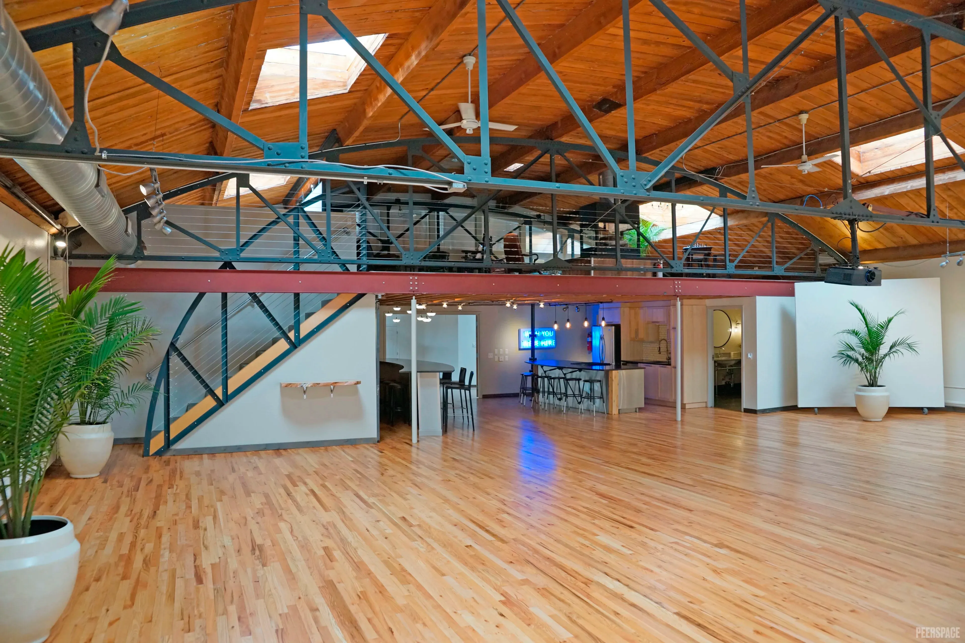 Sterling Event Space studio — full empty space with barrel vault, steel trusses, mezzanine, and daylight.